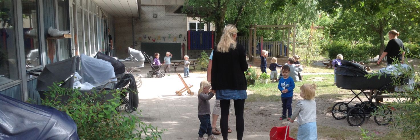 Børn og voksne på legepladsen i Børnehuset Mælkevejen